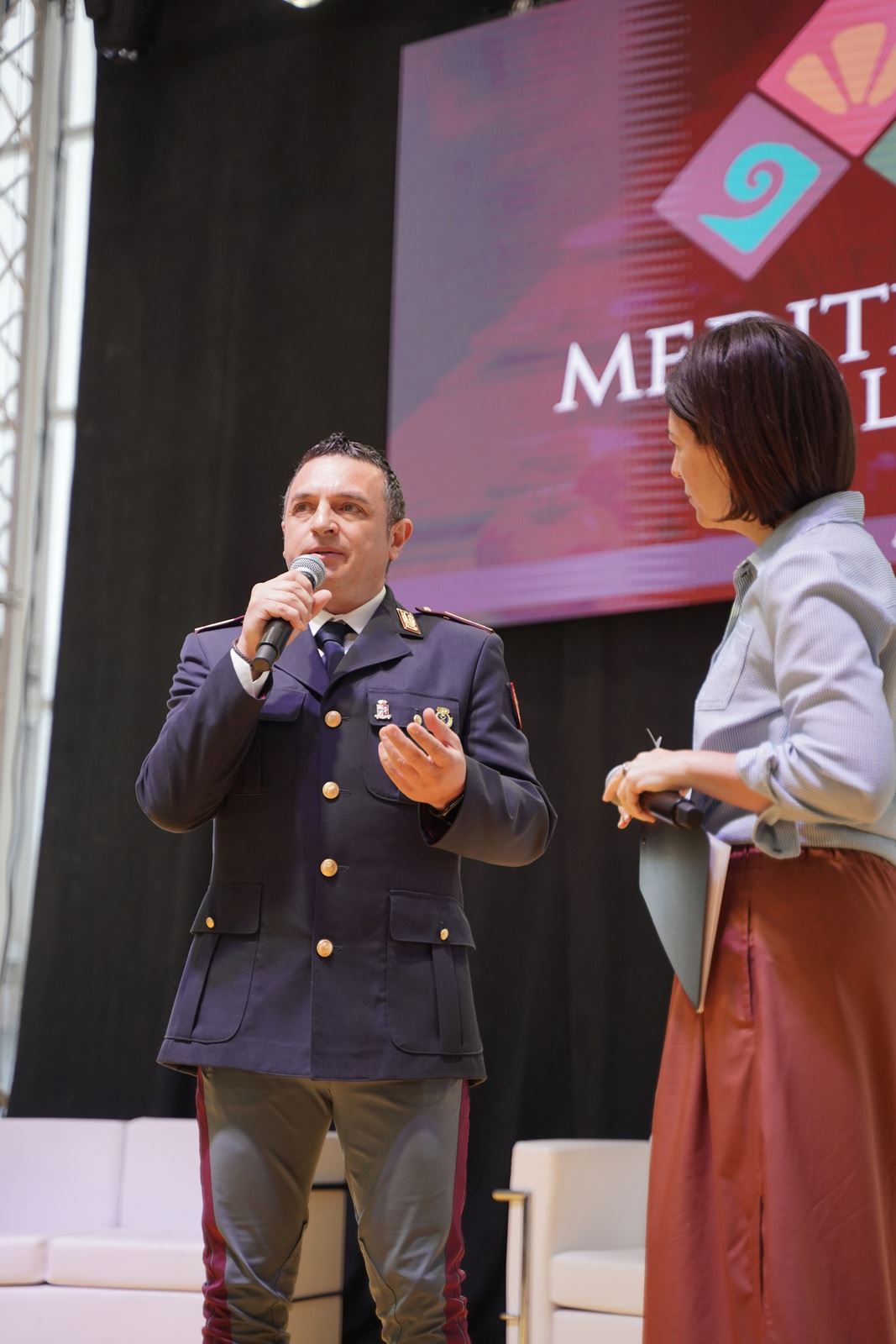 Un agente della Polizia di Stato parla agli studenti sul palco