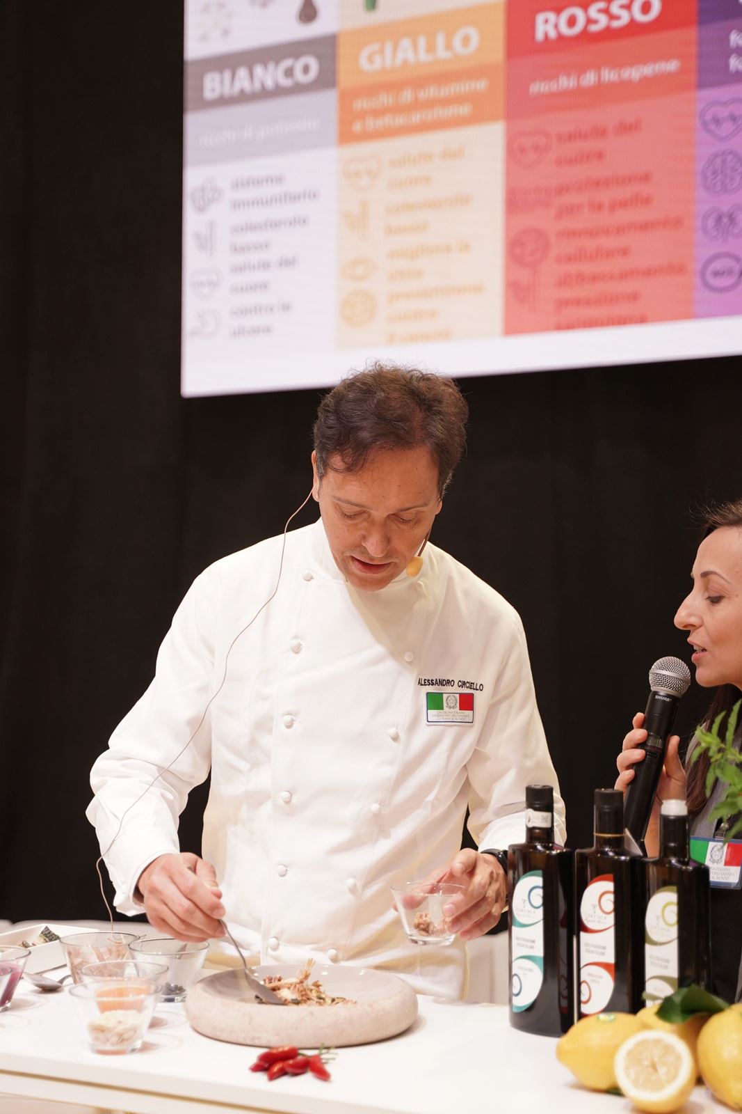 Chef durante uno showcooking con olio extravergine d’oliva e limoni